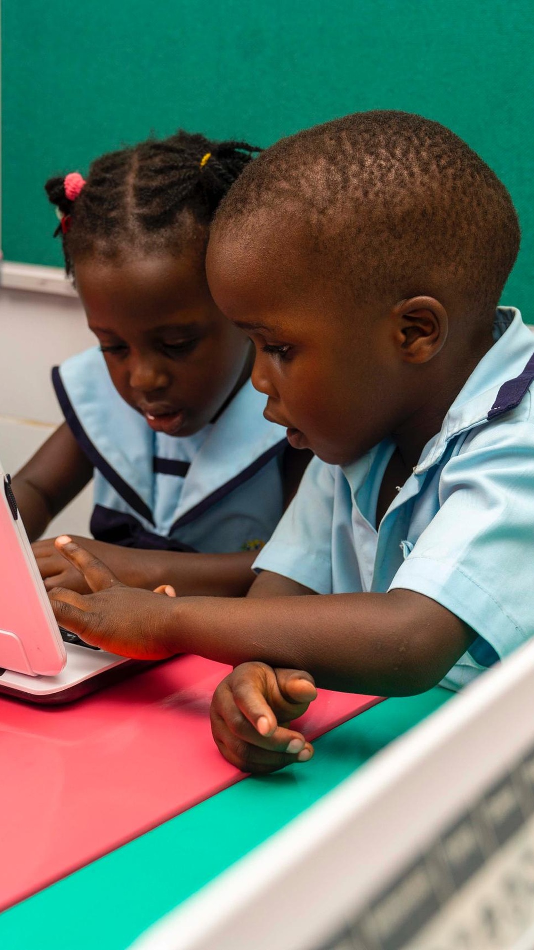 Children exploring a laptop in the school’s website photograph